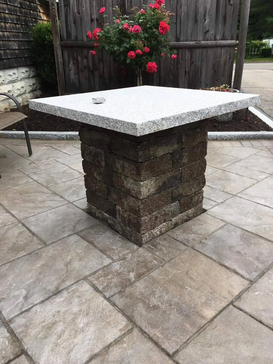 Stone and granite outdoor fire pit table on paver patio